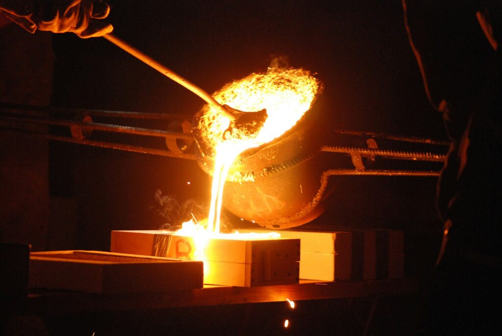 Logam cair dituang dari crucible ke cetakan
